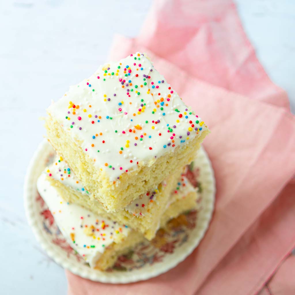vanilla sheet cake slices on plate, stacked